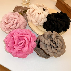 Detail of fabric camellia flower hair claws in five colors including pink white and black