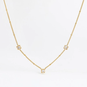 Détail du collier doré avec cristaux de zircon carrés sur une chaîne à maillons