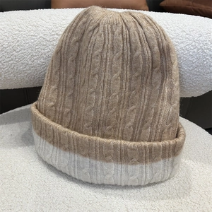 Close-up of chunky knit texture and two-tone color stitching on a warm winter beanie