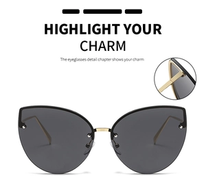 Close-up of cat-eye sunglasses featuring gray lenses and gold metal temple hinge detail