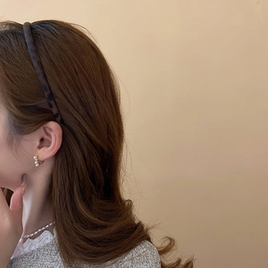Detail of leopard print headband and pearl earrings on model with elegant style