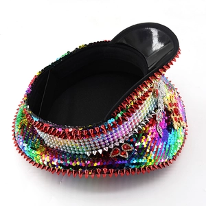 Detailed top view of rainbow sequin party hat with red spikes and pearl decorations