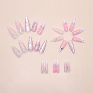 Close-up of pink cat eye press-on nails with 3D silver bows and pearl star accents