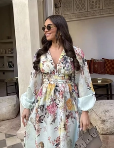 Detailed close-up of a floral print dress with deep V-neck and high waist design