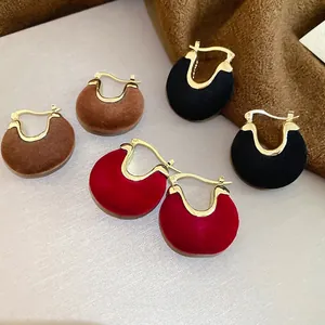 Three pairs of velvet semi-circle earrings in brown, black, and wine red with gold metal