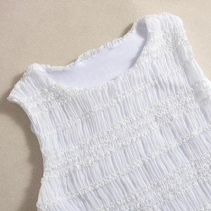 Détail du haut blanc sans manches avec texture froncée et col rond élégant