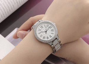 Close-up of a silver rhinestone ladies watch with Roman numerals on a model's wrist