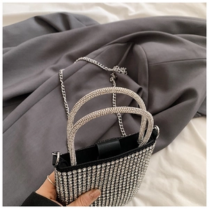 Detailed view of a silver rhinestone mini handbag with sparkling crystals and metal chain strap