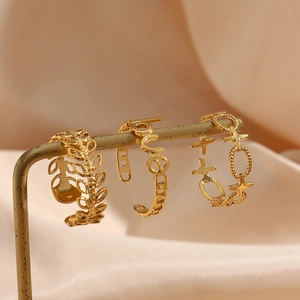 Detailed close-up of three gold hollow stainless steel open rings on a metal rack