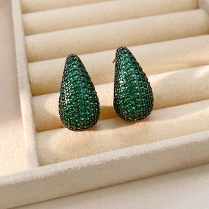 Vue rapprochée de boucles d'oreilles vintage en forme de goutte et zircon vert