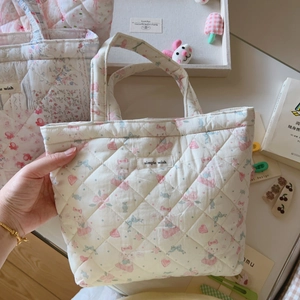 Quilted floral handbag with cute bunny pattern and simple wish label held by hand