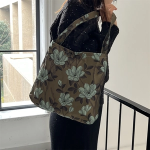 Dettaglio del tessuto jacquard floreale verde vintage su una borsa tote capiente