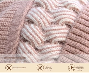 Detailed close-up of pink and white chunky knit fabric with textured cable pattern
