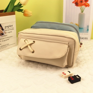 Dettaglio di astucci in tela minimalisti in beige e blu con tasca con lacci incrociati
