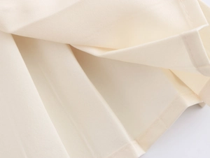 Détail rapproché de la texture du tissu en tweed blanc cassé avec plis naturels