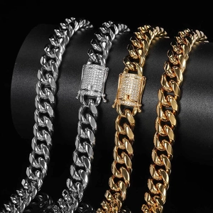 12mm gold and silver Cuban link necklaces with iced-out clasps on black background