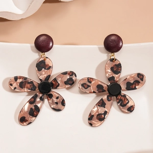 Detailed close-up of leopard print resin flower earrings on a white wavy stand