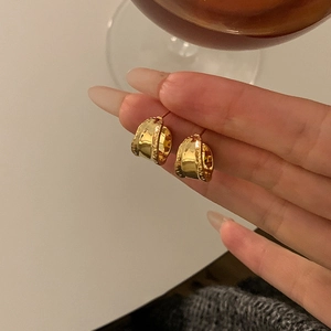Elegant gold chunky irregular hoop earrings with textured finish on model's hand