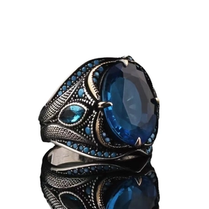 Vintage men's silver ring featuring a large blue sapphire gemstone and detailed carvings