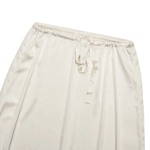 Détail de la taille d'une jupe en satin blanc avec bande élastique et cordon décoratif