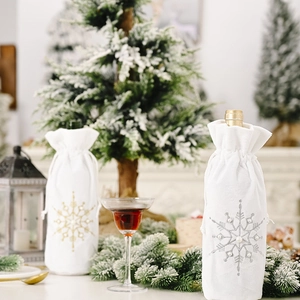 Detailed view of white velvet wine bottle covers with pearl snowflake embroidery and drawstrings