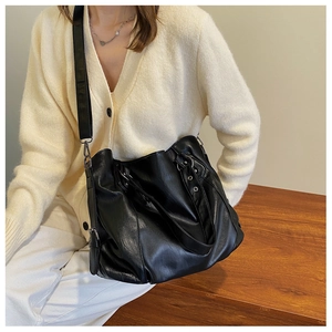 Detail of black soft leather tote bag with pleats and adjustable shoulder strap