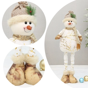 Detail of plush Christmas snowman doll featuring gold prints and a knitted hat