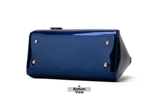 Detailed bottom view of navy blue patent leather handbag with four gold metal feet