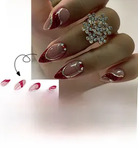 Detail of red glitter French press-on nails with gold accents and red rhinestones