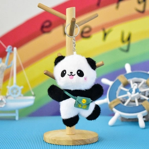 Cute plush panda keychain accessory hanging on a wooden display stand detail
