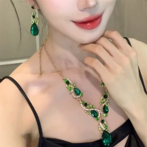 Close-up of model wearing green teardrop zircon necklace and matching earrings
