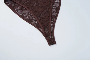 Detailed view of sheer lace lace texture and snap closure on dark brown bodysuit
