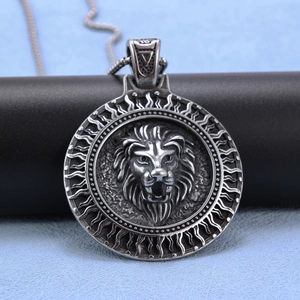 Detailed close-up of a silver stainless steel Viking lion head relief round pendant necklace