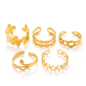 Five gold stainless steel rings featuring flower, snake, and star motifs on white background