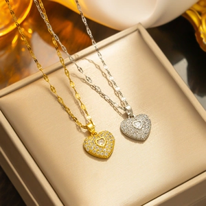 Luxury gold and silver heart necklaces with crystals on beige jewelry box display