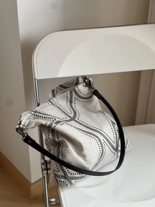 Detail of minimalist cotton linen tote bag with black geometric print on a white chair