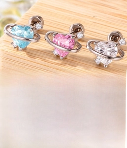 Macro detail of heart planet zircon stud earrings with flat back screw in medical steel