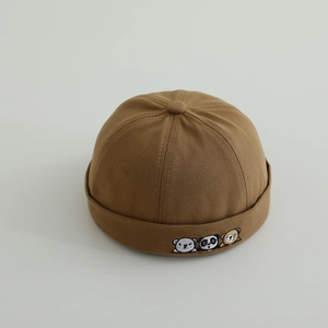 Close-up of brown cotton infant docker hat featuring detailed animal embroidery