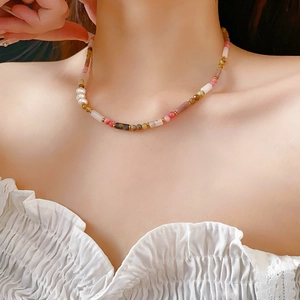 Close-up of bamboo-style pearl necklace with colorful natural stone beads on a model