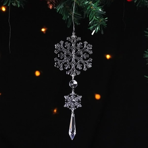 Transparent crystal snowflake ornament with water drop pendant on pine branch