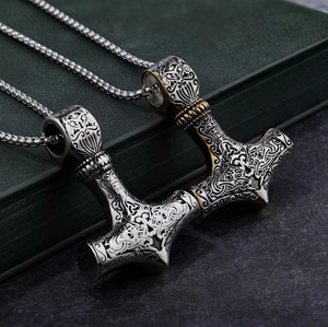 Macro detail of Mjölnir pendant with Viking Celtic patterns on vintage book edge