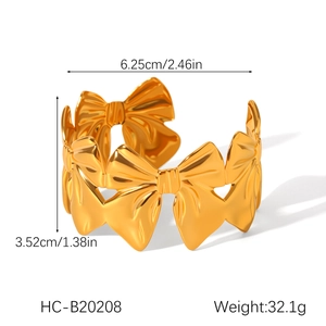 Vista macro del bracciale a fiocco in acciaio placcato oro 18K con dettagli di peso