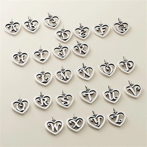 Macro view of 26 heart-shaped alphabet pendants in vintage silver with black engravings