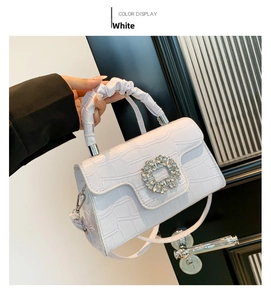 Vue détaillée du sac blanc à motif crocodile avec boucle en cristal et poignée plissée