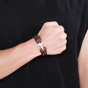 Close-up of men's dark brown leather woven bracelet with silver anchor hook clasp