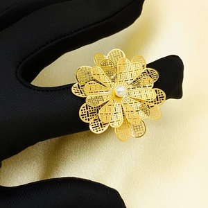 Detailed view of multilayer hollow flower ring with gold plating and center white pearl
