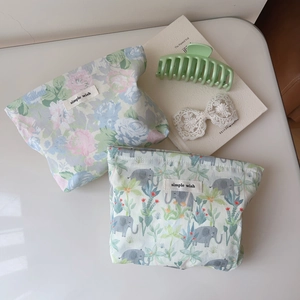 Detail of floral and elephant print cosmetic bags with simple wish label on cotton fabric