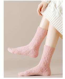 Close-up of pink coral fleece socks showing soft plush texture and cable knit pattern