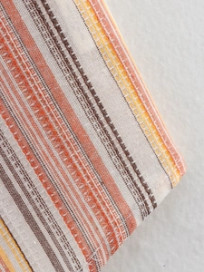 Close-up of the woven fabric texture and rainbow striped pattern on this summer vest