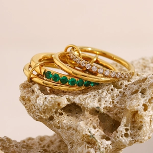 Macro shot of 18K gold plated multi-layer rings with green and white zircon on stone
